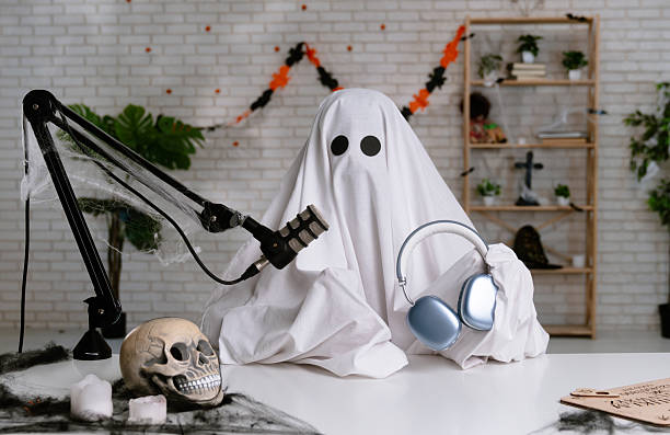 istock Funny ghost in a white sheet recording a podcast or blog 2236163471