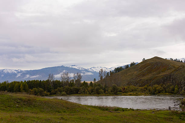 istock A serene river flows through a valley surrounded by mountains, the Altai mountain landscape is characterized by lush greenery along the river banks and arid fields. 2236164711