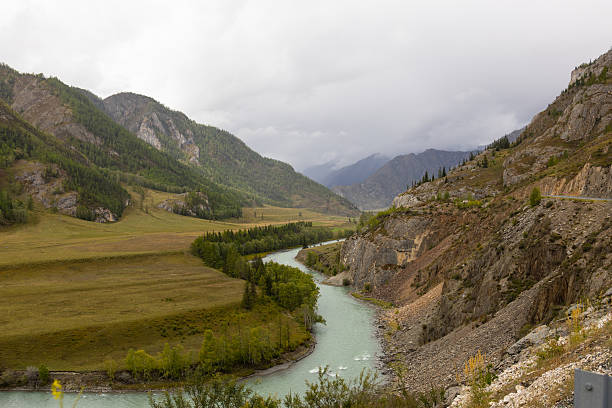 istock A serene river flows through a valley surrounded by mountains, the Altai mountain landscape is characterized by lush greenery along the river banks and arid fields. 2236165615