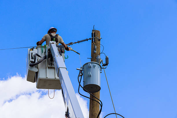 istock Electrician performs maintenance work on power line in clear blue sky at midday 2236172996