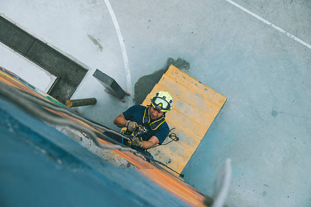 istock Firefighter rescuer descending a massive wall using a rappelling device in a multi-story building, wearing protective gear such as a helmet, harness, and carabiners. 2236176779