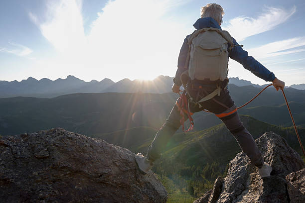 istock Climber balances on mountain top at sunset 2236177070