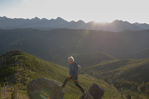 istock Climber balances on mountain top at sunset 2236177088