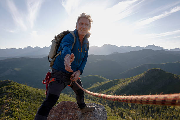 istock View down rope to climber on top of mountain 2236177097