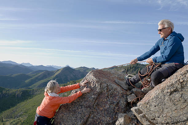 Mature couple climb on mountain top, Canadian Rockies