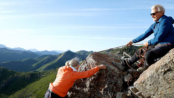 istock Mature couple climb on mountain top 2236177120