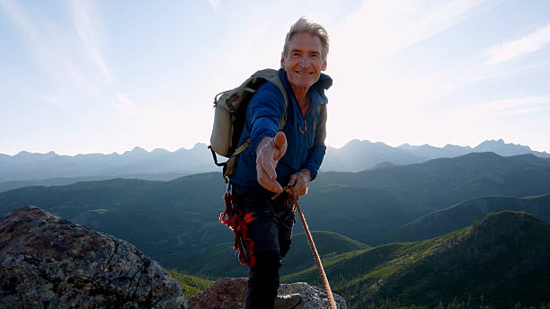 istock View down rope to climber reaching hand out for assistance 2236177132