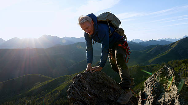 istock Climber jumps over gap on mountain top at sunset 2236177142