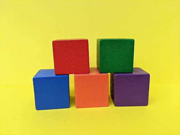 istock A group of colourful cube blocks isolated on yellow background 2236178662