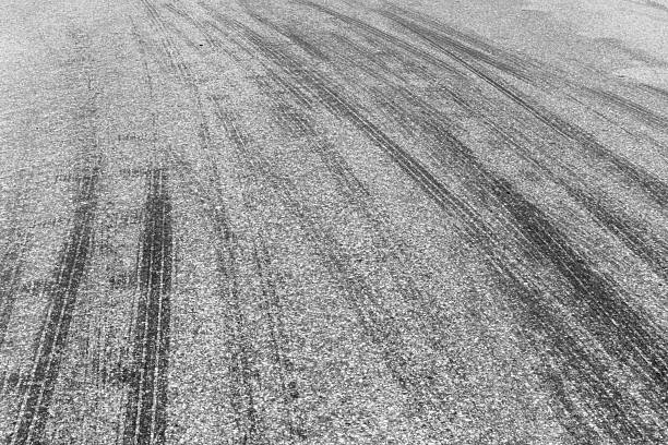 Black tire marks on road, Black rubber tire marks and tread marks, Tire trace track wheels texture and background, Auto tire tread grunge, Car wheel tyre tread track black tyre print, Aerial view.