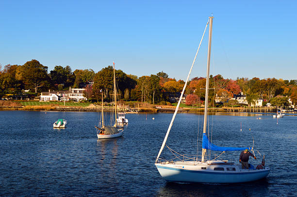 Greenwich, CT, USA October 27 An adult man prepares his sailboat for cruising on a fall day off the shore of Greenwich, Connecticut