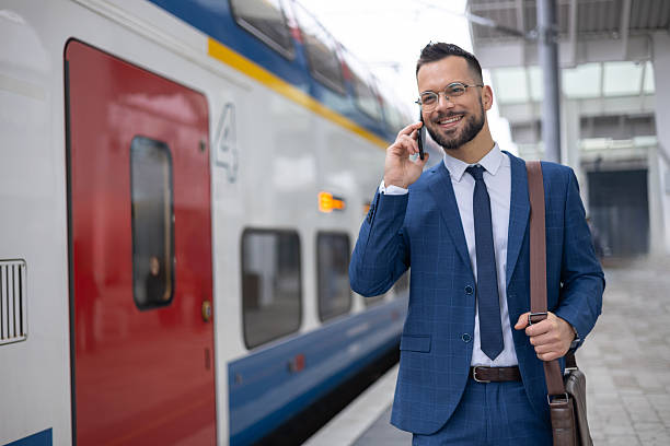 istock Young man is talking on phone while waiting of his train 2236187468
