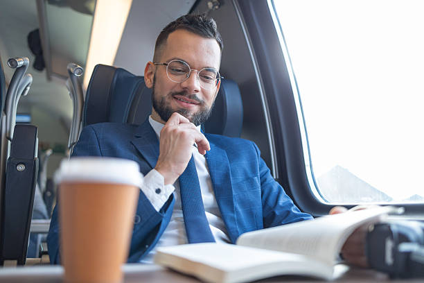 istock Young man is reading a book during his travel by train 2236187485