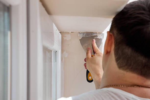 istock man with a spatula applying finishing putty on a window opening 2236187687