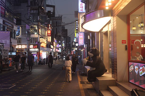 Seoul, South Korea-September 15, 2025: People walking down bustling commercial avenue in downtown Gangnam, Seoul, in the evening