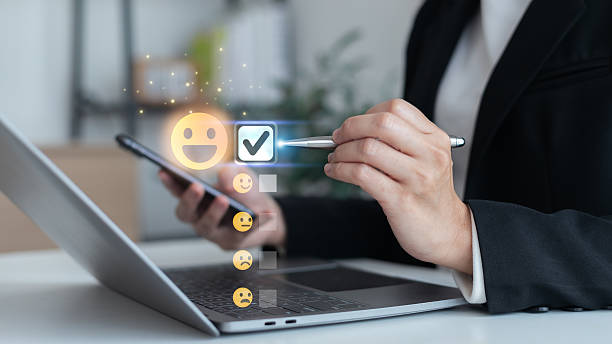 istock Businessman using digital device to select happy face emoji in online customer feedback and satisfaction survey concept for service rating and user experience. 2236193290