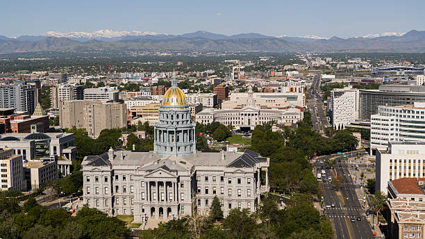 istock Panoramic view of Colorado State Capitol with snow-capped Rocky Mountains backdrop. Civic Center Park with Denver City Council building and metropolitan area stretch toward mountain range. 2236196682