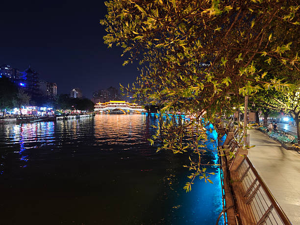 People on Jin river waterfront at night by the iconic Anshun Bridge in Chengdu, Sichuan, China.