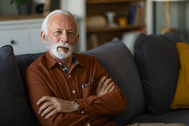istock Senior man sitting on sofa at home. 2236200543