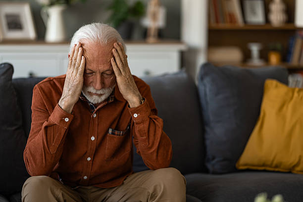 istock Unwell senior man having a headache while sitting at home. 2236200556