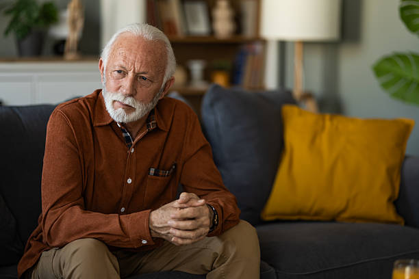 istock Pensive senior man sitting on sofa at home. 2236200582