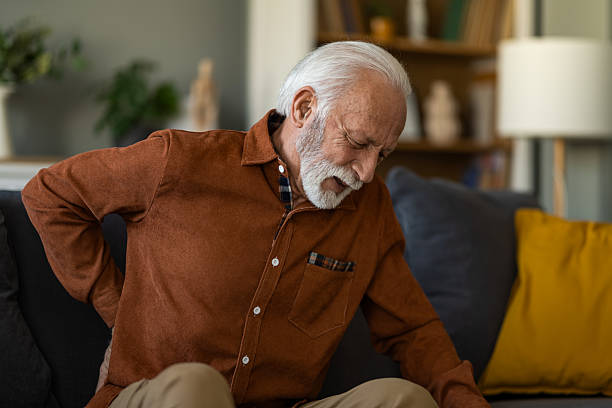 istock Unwell senior man having a backache while sitting on sofa at home. 2236200679