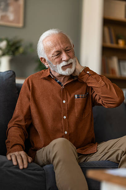 istock Unwell senior man having a neckache while sitting on sofa at home. 2236201298