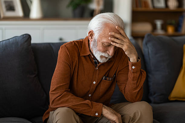istock Unwell senior man having a headache while sitting at home. 2236201340
