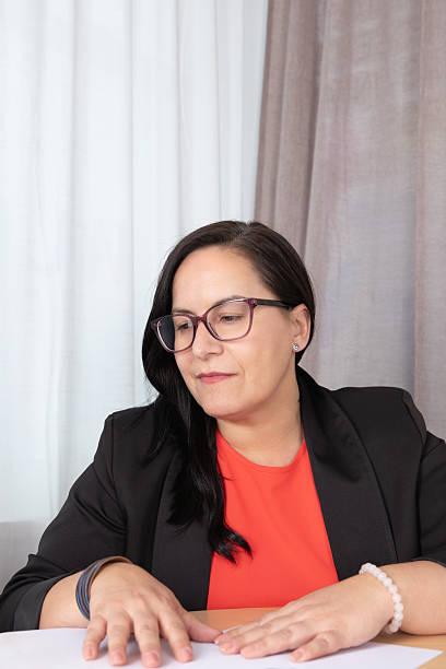istock Mature woman analyzing documents in an office with a relaxed expression, ideal for intellectual work or decision-making topics. Concept of strategic planning 2236202649