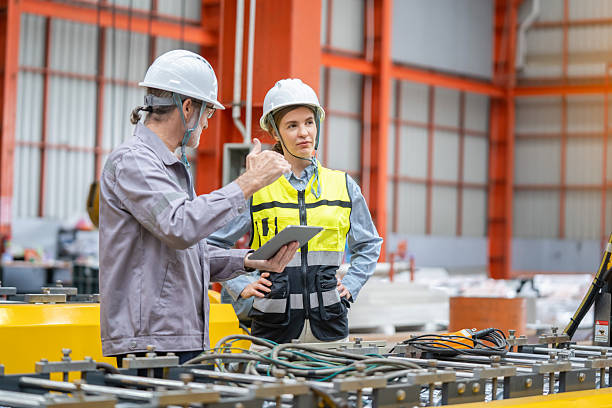 istock Senior engineer explaining production processes to a female industrial worker in a modern factory. Teamwork and collaboration in manufacturing industry. 2236202857