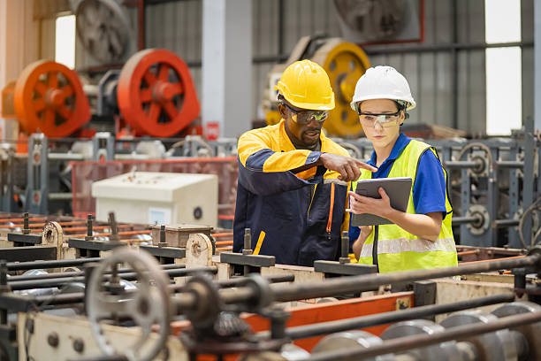 istock Industrial workers inspecting machinery and discussing workflow on a production line. Professional teamwork, safety, and precision in modern manufacturing. 2236203160