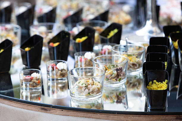 Catering service presenting delicious appetizers on mirrored table at event