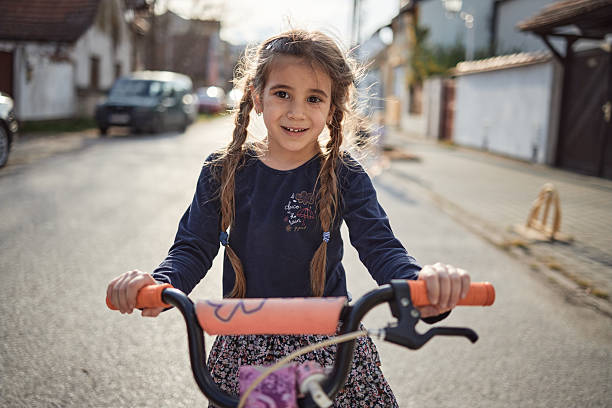 Girl is driving bicycle in the street.