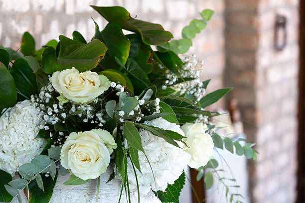 Stunning floral arrangement featuring white roses, hydrangeas, and lush greenery, perfect for weddings or special events