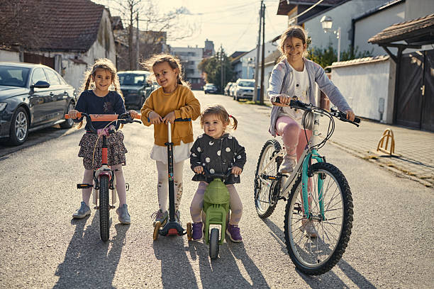 Girls are driving their vehicles in the street.