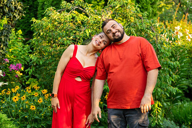 istock Couple smiling with heads touching in colorful garden setting 2236206720