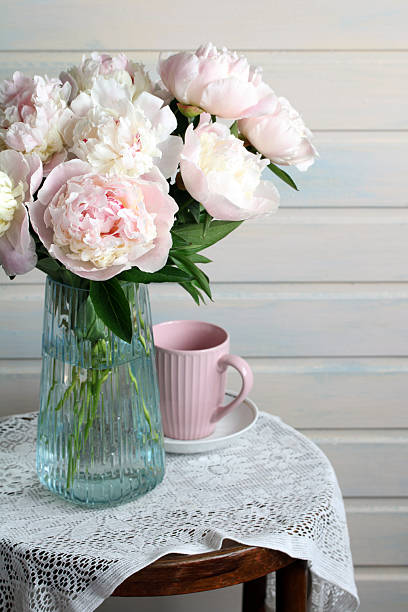 istock Peonies bouquet in blue vase with pink mug 2236208291