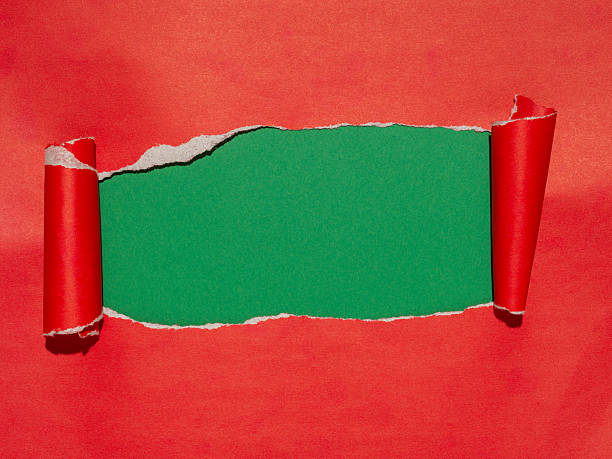 istock Torn red paper reveals a vibrant green background. 2236209593