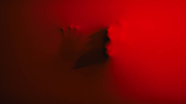 istock zombie face behind the red fabric 2236209975