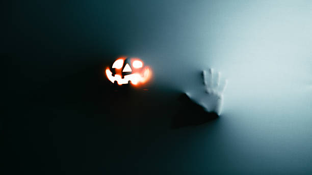 Ghostly Hands and Glowing Jack O Lantern Behind Fabric. High quality 4k footage