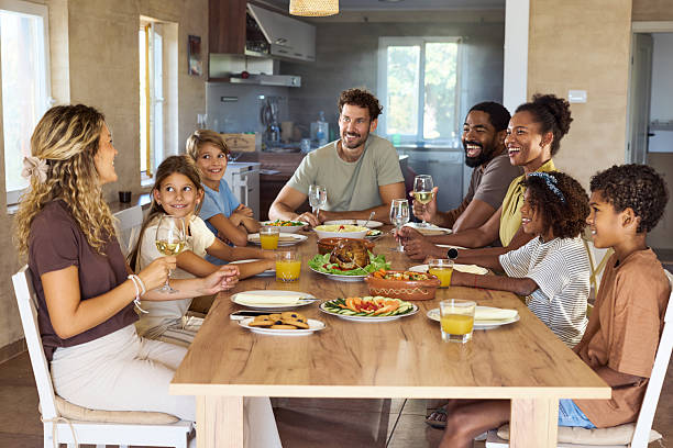 istock Happy diverse families talking during lunch at dining table. 2236212914