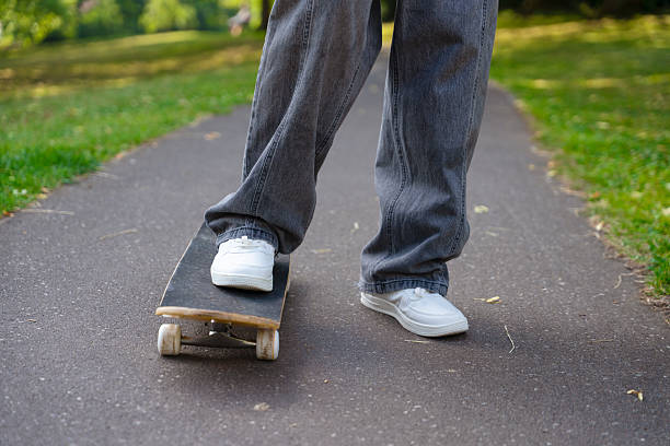teenage girl's legs on skates in front of park bench, sitting, skating, alone, legs