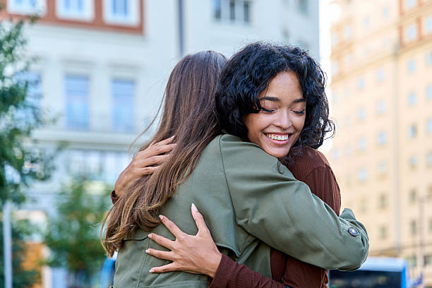 istock Two young women hugging each other in the city 2236217036
