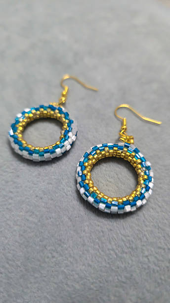 istock Handmade beaded and glass bead earrings on a light background. Copy space 2236217309