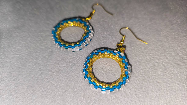istock Handmade beaded and glass bead earrings on a light background. Copy space 2236217310