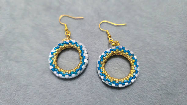 istock Handmade beaded and glass bead earrings on a light background. Copy space 2236217319