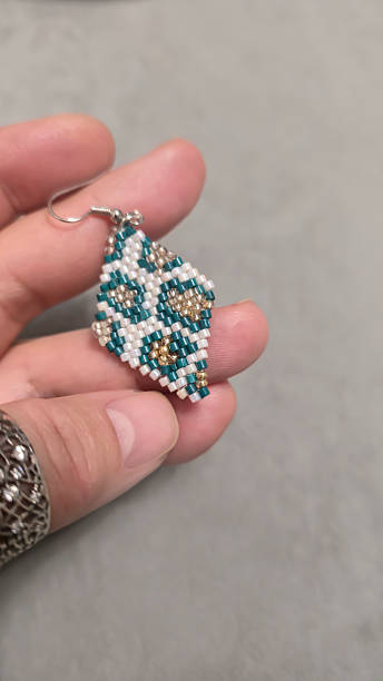 istock Handmade beaded and glass bead earrings on a light background. Copy space 2236217384