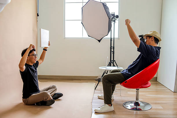 istock Photographer Captures Seated Model Holding A Blank Canvas During Creative Studio Shoot 2236217404