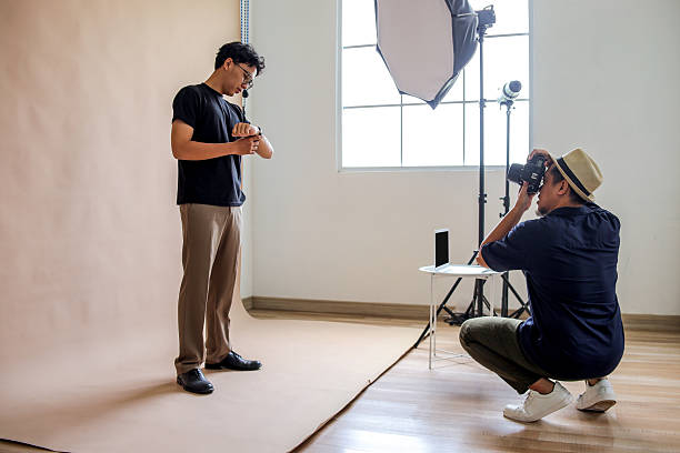 istock Photographer Asian Man Captures Model Checking Time On Smartwatch in Studio Setup 2236217415
