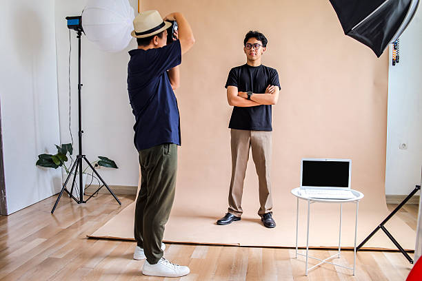 istock Model Poses With Arms Crossed While Photographer Takes Picture In Studio 2236217418